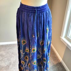 Long Blue Silver Sequin Skirt With Green Orange Purple Peacock Motif (Free Size). Holiday Festivities Or Any Day Fun Wear. 2” Elastic Waistband And Drawstring With Silver Balls For The Finish. Free Size Will Fit Most. The Skirt Measures 35-1/2” In Length, 14” Waist Band That Is Tight So It Will Stretch. 100% Rayon. Hand Wash Separately In Cold Water. New Without Tags. Traditional Blue Flowy Skirt, Traditional Flowy Blue Skirt, Blue Lined Skirt For Festivals, Blue Maxi Skirt For Festivals, Festival Blue Lined Maxi Skirt, Blue Lined Skirt For Festival, Traditional Blue Flowy Maxi Skirt, Traditional Blue Maxi Skirt, Blue Long Skirt For Festival