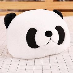 a stuffed panda bear laying on top of a bed