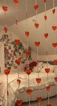 a bed with lots of red hearts hanging from the ceiling