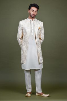 Off white open sherwani with mandarin collar, all over geometric abstract pattern, monotone resham and sequin embroidery. Paired with kurta with embroidered yoke and straight pant.
Components: 3
Pattern: Embroidered
Type Of Work: Resham and Sequin Work
Neckline: Mandarin Collar
Sleeve Type: Full Sleeves
Fabric: Crepe, Handloom Silk, Terry Rayon
Color: Off White
Other Details: 
Embellished buttons
Side slits on kurta
Kurta Closure: Front button placket
Note: The brooch and pocket square worn by t Open Sherwani, Embellished Buttons, Geometric Abstract Pattern, Tarun Tahiliani, Sequin Embroidery, Sequins Embroidery, White Boys, Full Sleeves, Geometric Abstract