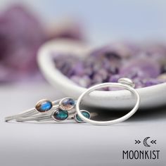 This dainty Silver Oval Labradorite Stacking Ring Set features a 6 x 4 mm oval cabochons, shown here in Labradorite. The bands have a smooth round wire band, shown here with a matte finish. These rings fit together as a stacking ring set and look great. Due to the nature of labradorite, individual pieces vary in color, but the stones we use all have sheen, color play, and depth. Sterling Silver Stacking Rings, 6 x 4 mm Cabochon Stones Dimensions: - Each Band: 1 mm (approx. 0.01 in), From Finger Oval Moonstone Fusion Ring Gift, Fusion Style Oval Moonstone Ring Gift, Oval Opal Stackable Rings, Sterling Silver Stacking Rings, Stacking Ring Set, Color Play, Silver Stacking Rings, Ring Fit, Stacking Ring