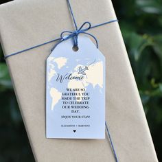 a gift wrapped in brown paper with a blue string tied around it and a welcome message on the tag