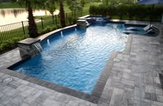 a swimming pool surrounded by landscaping and trees