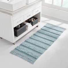 a bathroom with two sinks and a rug on the floor