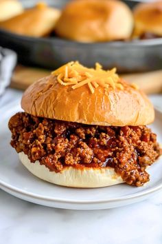 a sloppy joe sandwich sitting on top of a white plate