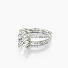 an engagement ring set with a cushion cut diamond in the center and side stones on each band