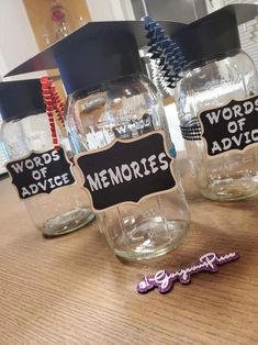 three mason jars with graduation caps and words on the lids are sitting on a table