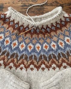 an old sweater is being worked on by someone using knitting needles to sew it