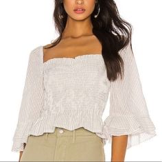 Shop aclosetjourney's closet or find the perfect look from millions of stylists. Fast shipping and buyer protection. Blue Life Layla Crop Top White & Gray Pin Strip Smocked Bodice & 3/4 Layered Ruffle Sleeves Square Neckline can be worn on or off shoulder Size Small 50% Cotton & 50% Rayon Blue Smocked Summer Top With Ruffles, Blue Sleeveless Smocked Top With Ruffles, Ruched V-neck Smocked Top, Feminine Fitted Off-shoulder Smocked Top, Feminine V-neck Smocked Top With Ruffles, Blue Life, Square Necklines, White Crop Top, Smocking