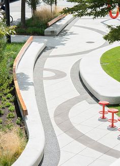 an empty park with benches and trees in the background