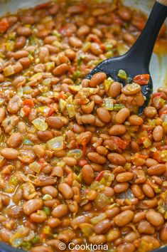 the beans are being stirred with a spoon