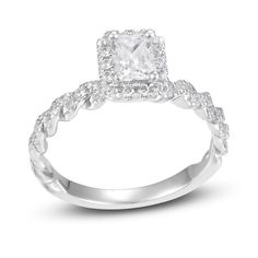 an engagement ring with a square cut diamond in the center and braided shants around the band