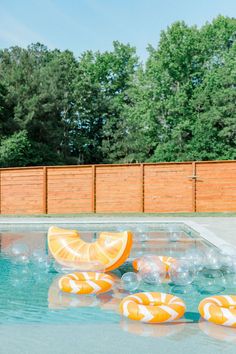 an inflatable orange slice floating on top of a swimming pool surrounded by bubbles