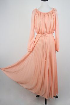 "1970s maxi dress. Peach colored light weight sheer polyester fabric on the outside and lined with an opaque nylon fabric. Long sleeves are unlined and are open from the shoulder to about the elbow with elastic at the wrists. Blousy top, elastic waist, and accordion pleated skirt. There is not a lot of stretch to the waist. Skinny fabric cord belt. Fastens down the back with a metal zipper. Only labels are a size 11/12, ILGWU, and dry clean only. Freshly laundered. (I have to laugh when polyeste Pleated Orange Maxi Dress For Spring, Spring Orange Pleated Maxi Dress, Modest Full-length Maxi Dress For Spring, Modest Full Length Maxi Dress For Spring, Modest Summer Evening Maxi Dress, Vintage Chiffon Maxi Dress For Spring, Peach Flowy Maxi Dress For Party, Flowy Peach Maxi Dress For Party, 1970s Style Long Sleeve Maxi Dress For Summer