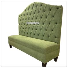 a green couch sitting on top of a wooden frame