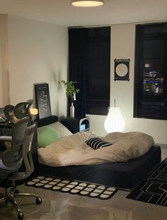 a bed sitting in the middle of a living room next to a desk and chair