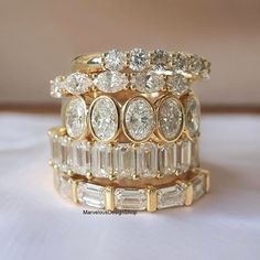 a stack of gold rings with white diamonds on each one and two rows of baguettes in the middle