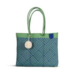 Meet your new favorite beach bag. This super flexible, water-resistant woven Super Tote is made using 100% recycled plastic to fit all your beach-day essentials with a spacious interior and comfortable handles for toting anywhere.  The Super Tote is the perfect size and style to carry everything you may need for a beach vacation including your towel, go-to book, sunnies, snacks, and as many sunscreens as you want.  Handmade with amor from ethically sourced high-quality materials, this bag will become your wardrobe favorite for every occasion from a picnic to a beach day to carrying your farmer's market finds.  Comes with a FREE Pompom while supplies last. Colors and sizes may vary and are not always the ones pictured. How am I made?  My journey begins in Oaxaca, where the artisans that mak Casual Travel Shoulder Bag Made Of Recycled Materials, Packable Blue Rectangular Shoulder Bag, Blue Reusable Tote Beach Bag, Blue Reusable Tote Shoulder Bag, Casual Everyday Bag Made From Recycled Plastic, Casual Everyday Bags Made From Recycled Plastic Bottles, Blue Recyclable Beach Bag For Summer, Everyday Bags Made From Recycled Plastic Bottles, Eco-friendly Recyclable Shoulder Bag With Double Handle