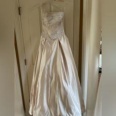 a wedding dress hanging on a door