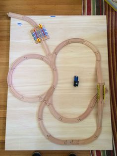 a toy train set sitting on top of a wooden table next to a pair of black shoes