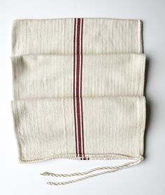 a piece of cloth with red and white stripes on the side, sitting on top of a table