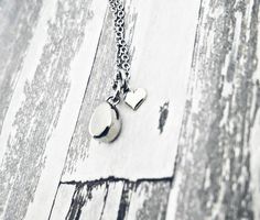 "Thos beautiful necklace is perfect for the minimalist. It features a 1/2\" teardrop pendant, which doubles as a mini urn so you can hold your loved one close to your heart at all times. The back unscrew so you can add ashes. Next to the urn is a tiny sterling silver heart charm. The chain and urn are stainless steel and will never tarnish. Each comes with a funnel and filling instructions. To see more urn jewelry please visit JessicaDennisDesigns.etsy.com" Silver Minimalist Charm Necklace For Keepsake, Silver Teardrop Necklace With Heart Charm, Sterling Silver Teardrop Charm Necklace For Anniversary, Keepsake Silver Teardrop Pendant Necklace, Silver Teardrop Pendant Necklace For Keepsake, Sterling Silver Teardrop Pendant Charm Necklace For Anniversary, Anniversary Sterling Silver Teardrop Pendant Charm Necklace, Anniversary Sterling Silver Teardrop Charm Necklace, Minimalist Teardrop Charm Necklace For Anniversary