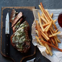 a steak and french fries on a cutting board