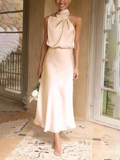 a woman standing in front of a doorway wearing a dress