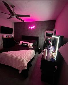 a bed room with a neatly made bed and a neon sign