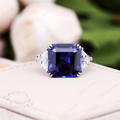 a blue and white diamond ring sitting on top of a box