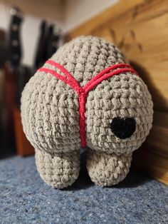 a crocheted stuffed animal with a red ribbon around its neck