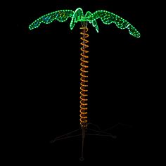 a lit up palm tree on top of a black background with green lights in the shape of leaves