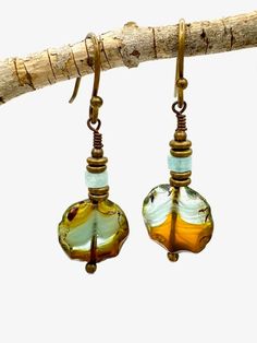 Pretty earrings with Czech glass blue and amber round bead accented by stacked small golden rondelle beads. Glass has a raw cut featured edge. Hooks are antique bronze plated, hypoallergenic French ball dot. Carefully packaged in organza bag and placed in brown kraft box and secured with aqua twine. A unique addition to your boho style and makes a great handmade gift! Bohemian Glass Beaded Earrings With Round Beads, Adjustable Bohemian Glass Beaded Earrings, Blue Beaded Earrings, Golden Beads, Kraft Boxes, Earring Ideas, Pretty Earrings, Brown Kraft, Earrings Boho