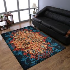 a living room with a black couch and blue rug on the floor next to a window