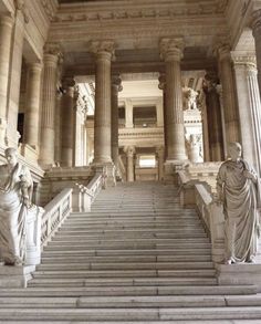 there are many statues on the stairs in this building