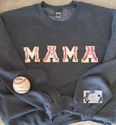 a sweatshirt with the word mama on it next to a baseball