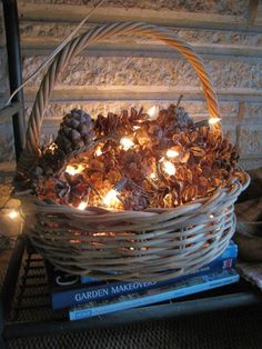 a basket filled with pine cones and lit candles