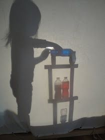 the shadow of a person standing in front of a shelf with two bottles on it