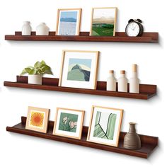 three wooden shelves with pictures and vases on them