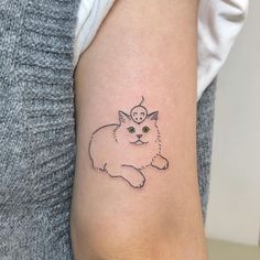 a small cat tattoo on the right arm and shoulder, with a tiny mouse on it's head