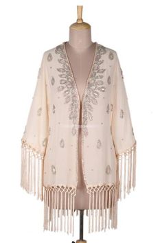 When you reach for this jacket you'll know it's going to be a special night out. Presented by Vijay Singh in India the open jacket is crafted from polyester crepe in the palest of apricot shades--think ivory with a bit more warmth. Artisans lavish the jacket with silvery glass beads and iridescent sequins that play with the light. Long silky fringe lends bohemian chic to the cuffs and hem. Beaded Fringe Long Sleeve Outerwear For Spring, Long Sleeve Outerwear With Beaded Fringe For Spring, Long Sleeve Summer Evening Outerwear, Summer Evening Long Sleeve Outerwear, Summer Evening Long Sleeve Cardigan, Winter Outerwear With Beaded Fringe And Long Sleeves, Summer Sequined Long Sleeve Outerwear, Sequined Long Sleeve Summer Outerwear, Bohemian Embellished Spring Outerwear