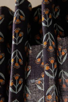 an orange and black flowered design on fabric