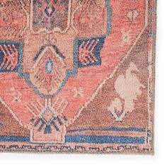 an old rug with various colors and patterns on it, including blue, pink, orange and white