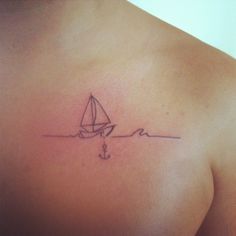 a small sailboat on the back of a man's upper arm and shoulder