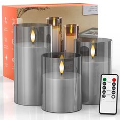 four candles with remote controls in front of a box