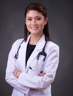 a woman wearing a white lab coat and stethoscope standing with her arms crossed