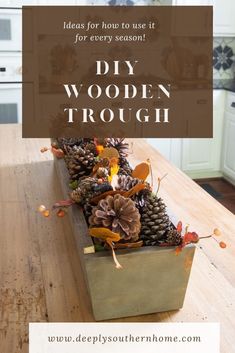 a wooden trough filled with pine cones on top of a table