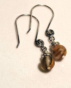 These earrings are made with unique and stunning agate beads. When the stones catch the light they are brilliant browns with hints of yellow, orange, and black.  The stones are highlighted by Swarovski crystal beads and decorative silver earwires. Brown Czech Glass Bead Earrings, Brown Czech Glass Teardrop Earrings, Nickel-free Brown Beaded Earrings With Czech Glass, Nickel-free Brown Czech Glass Beaded Earrings, Brown Earrings With Natural Stones And Round Beads, Brown Teardrop Czech Glass Jewelry, Brown Czech Glass Teardrop Jewelry, Elegant Brown Czech Glass Earrings, Nickel Free Brown Earrings With Czech Glass