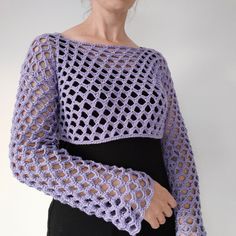 a woman wearing a purple crochet sweater with sleeves and an openwork design