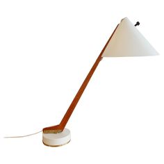 a lamp that is on top of a white base and has a brown wooden stick sticking out of it